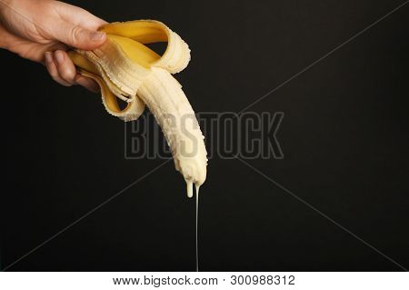 Big Banana And Drops Of Condensed Milk. Concept Of Sex, Man Ejaculation. Sperm And Orgasm.