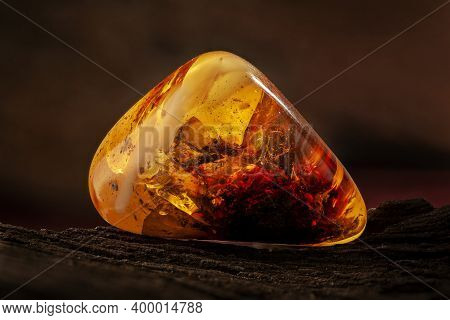 Beauty Of Natural Raw Amber. A Piece Of Yellow-red Transparent Natural Amber With Inclusions In It.
