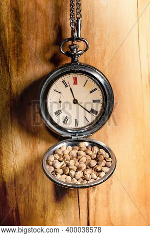 Old Pocketwatch With Hemp Seeds On A Wooden Wall. Close Up.