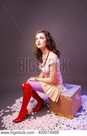 Portrait Of Young Caucasian Female In Red Sexy Boots Posing In Colorful Clothing In Dolly Style And