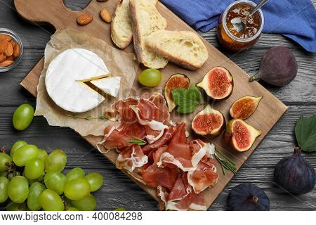 Board With Delicious Figs, Proscuitto, Cheese And Grapes On Grey Wooden Table, Flat Lay