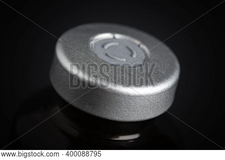 A Macro Shot With Selective Focus Of An Amber Color Vaccine Injection Bottle Set On A Dramatic Black