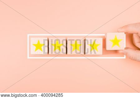 Concept Excellent Rated Services. Hand Putting Wood Block Cube Gold Five Star Shape On Wooden Table 