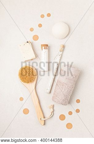 Eco Friendly Soap Bar, Tooth Brushes, Cotton Swabs, Bath Salt, Clay Mask And Washcloth On Neutral Ba
