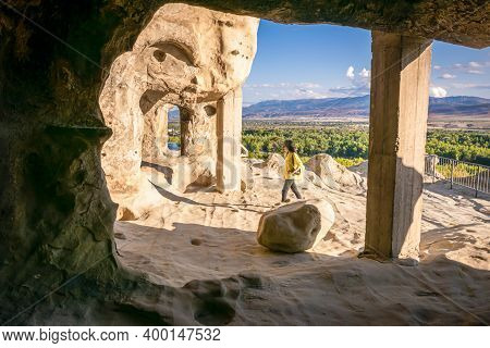 Female Tourist Walks Around Uplistsikhe Cave City Exploring Architectural Structures