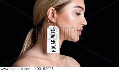 Tyranny In Family And Sexism Concept. Desperate Woman With Label On Her Ear With Inscription Housewi