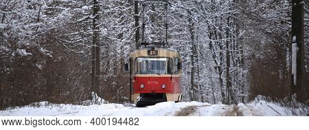 Kiev, Ukraine - December 25, 2018: Snowy Winter. Old Red Retro Tram Is Rolling (going) Along Commute