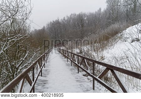 Winter Landscape With A Footbridge At The Bottom Of The Ravine.