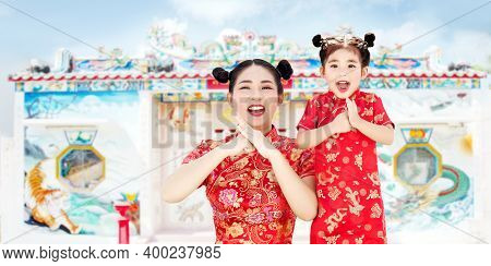 Chinese Family Mother And Girl Greeting Action As Chinese Tradition With Cheongsam Dress On Blur Chi