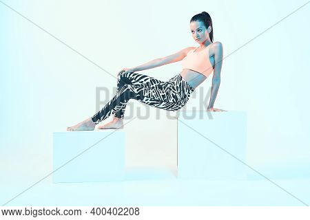 Fitness Girl Posing In Sport Clothes In Neon Light. Fit Young Model With Perfect Body Shapes. Health