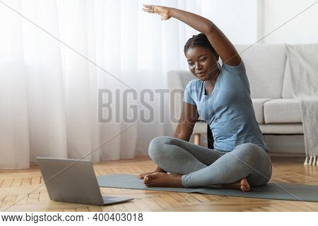 Online Fitness. Smiling Black Lady Training In Front Of Laptop At Home, Sporty African American Woma