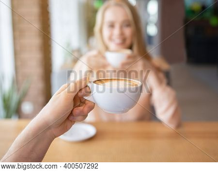 Young Gyu Drinking Coffee With His Girlfriend At Cafe, Focus On Hand Holding Drink. Millennial Coupl