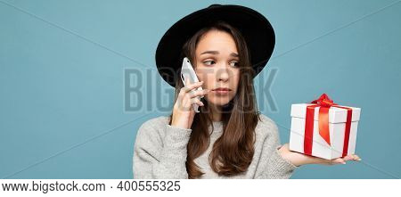 Photo Of Beautiful Upset Young Brunette Woman Isolated Over Blue Background Wall Wearing Black Hat A