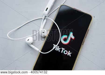 Tver, Russia-february 12, 2020 Tik Tok Logo On The Smartphone Screen And White Wireless Headphones O