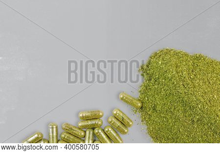 Coarse Grind Mitragynina Speciosa Or Kratom Powder And Kratom Pills On Grey Background