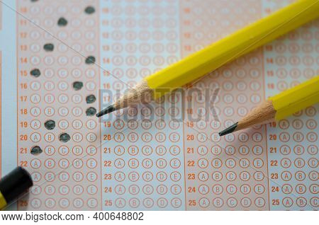 Close Up Of Multiple Choice Examination Form Or  Optical Mark Paper And Yellow Pencil,selective Focu