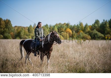 A Pretty Girl Came To The Country Equestrian Club And Rides A Horse Through The Fields In The Fall.