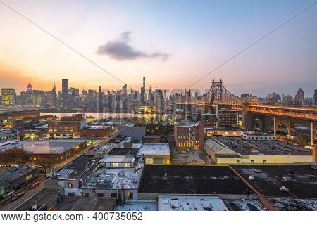 Queens, New York, USA view with the Queensboro Bridge towards Manhattan at dusk.