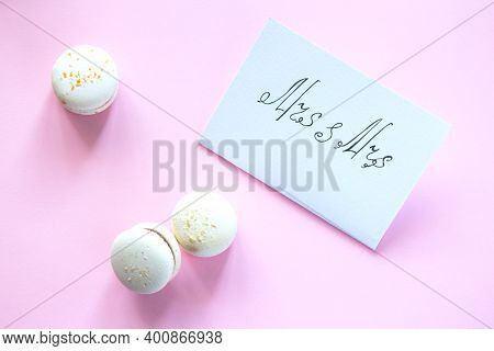 White Card With The Inscription Mrs And Mrs On A Pink Background. Sweets Macarons On A Bright Backgr