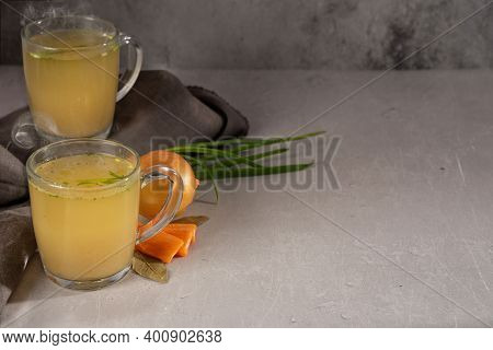 Hot Homemade Chicken Broth With Collagen And Amino Acids In A Transparent Glass Cup With Gray Napkin