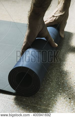 Middle-aged Man Picks Up A Yoga Mat At Home
New Normal Concept, Exercising At Home