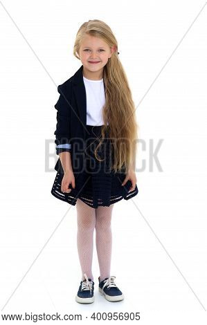 Cute Girl Elementary School Student. Cute Long Haired School Girl Wearing Blue Jacket And Skirt Posi