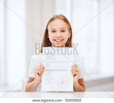 education and school concept - little student girl with test and grade at school