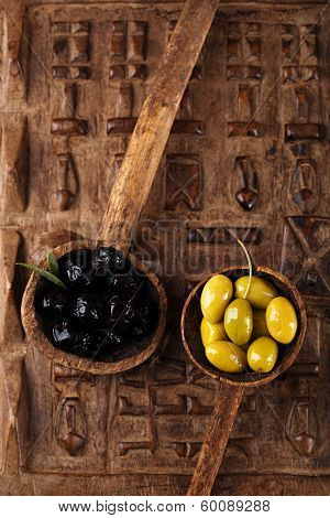 marinated Olives in old spoon with morrocan  orament on wood, shallow dof