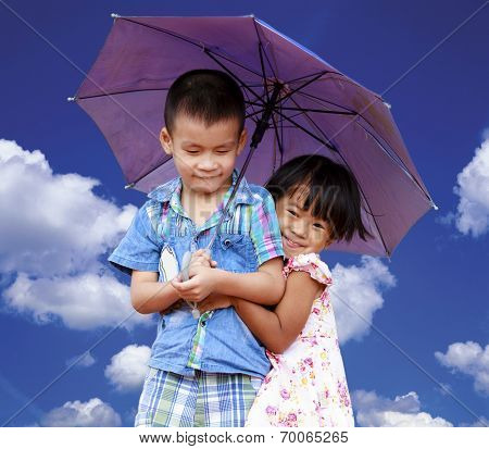 Smiling boy and little girl with umbrella
