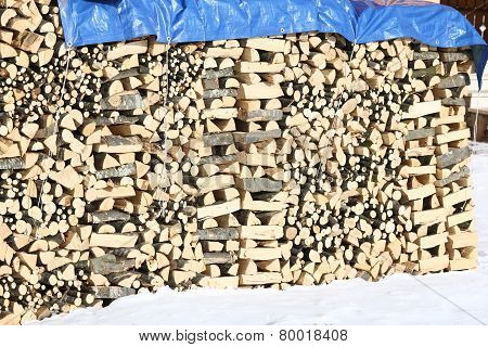 Woodshed With Pieces Of Wood Piled Up For The Winter And Snow