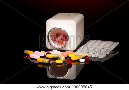 Colorful pills over dark background. Red Spotlight above