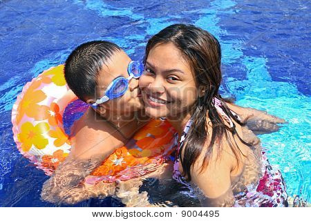 Felice ragazzo bacio mamma In piscina