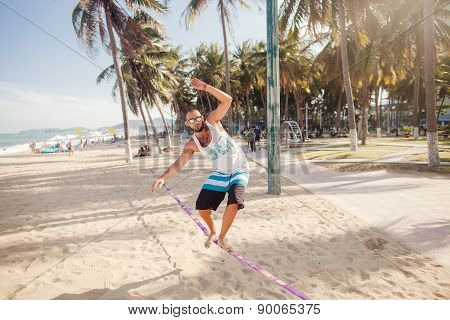 Teenager Man Balancing On Slackline In Tropics