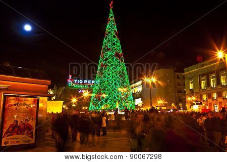 People Have Fun In Christmas Time Passing The Famous Illuminated Christmas Tree At Puerta Del Sol