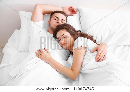 Happy couple snoozing on bed