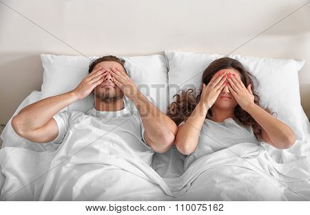 Happy couple snoozing on bed
