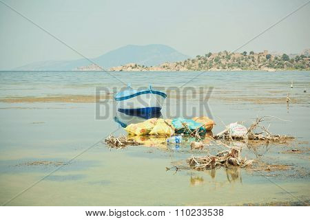 Fishing Boat On The Water Of Drying Lake Bafa With Pollution By Garbage
