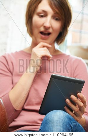 Shocked Woman Reading E-book At Home