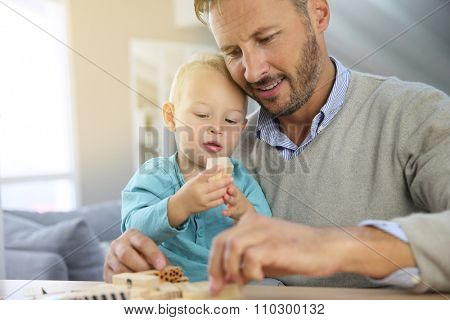 Daddy with 2-year-old boy playing with wooden blocks