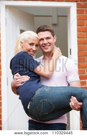 Man Carrying Woman Over Threshold Of New Home