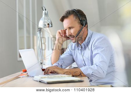 Businessman teleworking, headset on