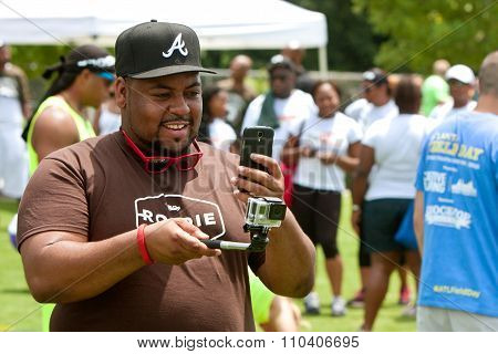 Man Uses Smart Phone To Operate GoPro Camera At Event