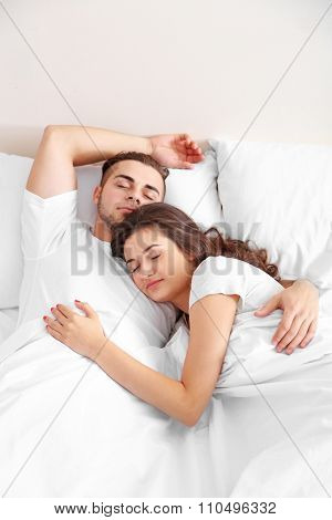 Happy couple snoozing on bed