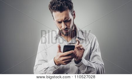Disappointed Man Typing With His Smartphone