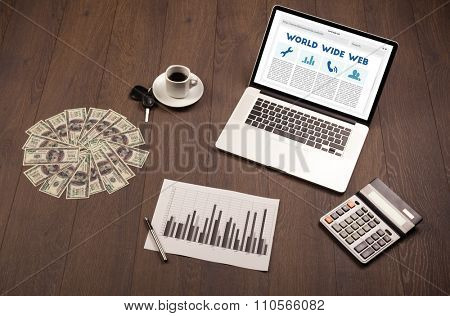 Laptop computer on wooden desk with office suplies