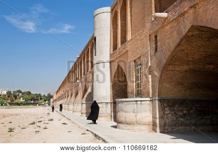 Women Walk Along The Stone Cross Dried River, Iran