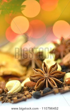christmas spices, nuts, cookies and dried fruits on bokeh background