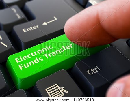 Pressing Green Button Electronic Funds Transfer on Black Keyboar