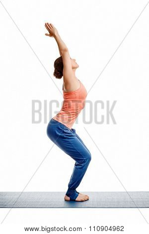 Sporty fit woman doing Surya Namaskar ashtanga vinyasa yoga asana Utkatasana - chair pose isolated on white