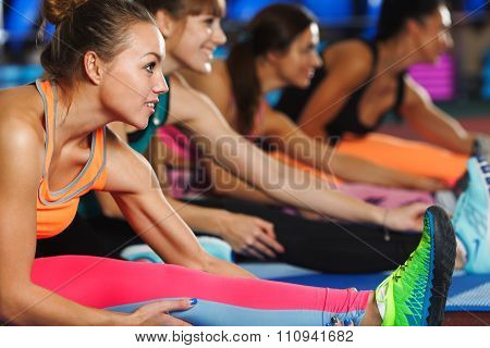 Women stretching legs in sports club